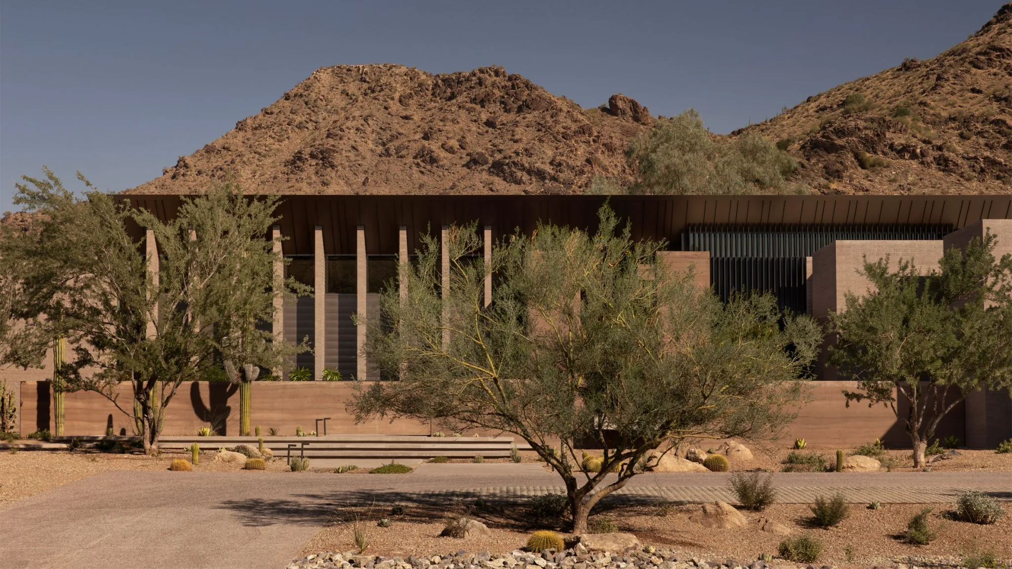 Dry Creek set low against a desert mountain, its rammed-earth walls the colour of the land.