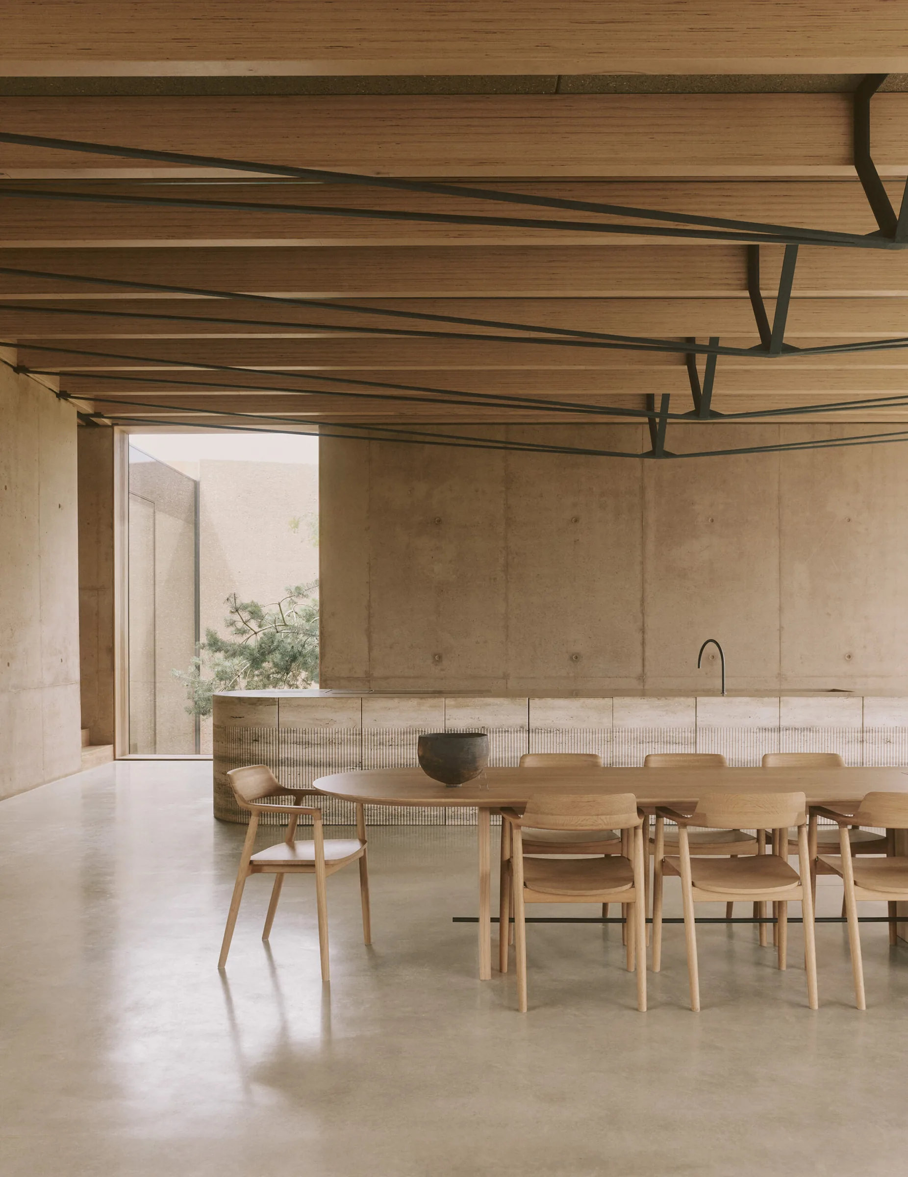 The dining room beneath the timber roof, with a long oak table.