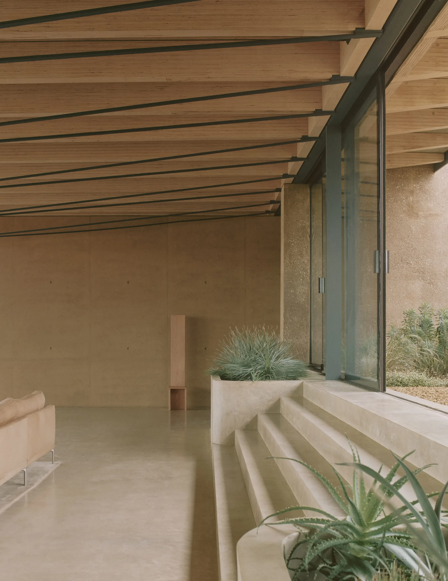 A concrete threshold and steps between the gallery and the garden.