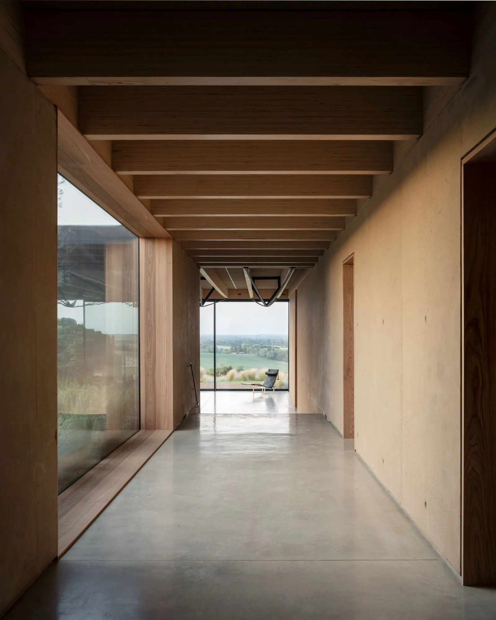 A top-lit gallery framed by exposed Douglas fir beams running toward the view.